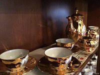 Photo of porcelain gold leaf tea cups and matching saucers