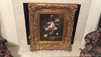 Front view of framed floral canvas print showing detailed ornate gold frame and floral artwork.
