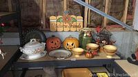 Overview of fall decorations on black metal shelving unit.