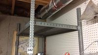 Full view of the upper shelving section showing grey metal frame and pegboard background