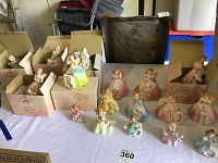 View of 17 porcelain birthday girl figurines from ages 2 to 18 minus numbers 1 and 6, some still in original boxes.