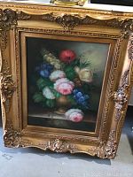 Full view of the floral oil painting on canvas with ornate gold tone frame showing size and labelling.