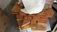 Stack of Douglas fir dog-eared fence boards showing top angled cut ends and natural wood grain.