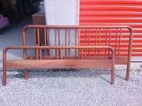 Front view of headboard and footboard leaning against storage unit
