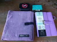 All four items arranged on a wooden surface: two planners and two pill organizers.