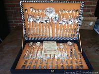 Open storage case showing two-tiered arrangement of forks, spoons, knives and serving pieces