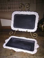 Two handmade upcycled mini chalkboards made from silver plated trays with ornate white frames and black chalkboard surfaces, one displayed on a golden stand and the other resting flat on a wooden surface.