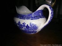 Blue Willow Homer Laughlin ceramic gravy boat side angle showing handle, spout, and detailed Blue Willow pattern.