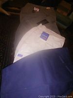 Four pairs of cotton men's shorts in various colors including white with an Urban Code tag visible on one of the shorts.