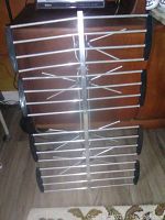 Full front view of the vintage portable TV antenna showing horizontal metal rods and black plastic end supports.