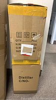 Two cardboard boxes labeled 'Distiller' stacked vertically, one sealed with yellow tape