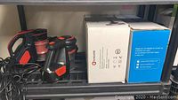 Two cordless stick vacuums visible on shelf with accompanying boxes.