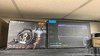 Original boxed PXN V3 Pro gaming racing wheel and Morphus GX920 Commander RGB keyboard boxes side by side