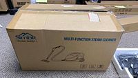 Closed cardboard box labeled Simbr Model SM0011 multi-function steam cleaner with product illustration.