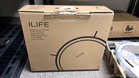 Box of iLife robotic vacuum cleaner model V5S Pro in cardboard packaging with black text and device outline.