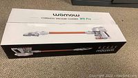 Box packaging of Womow W9 Pro cordless vacuum cleaner showing product image and branding.