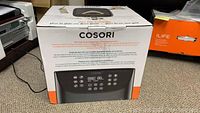 Sealed Cosori air fryer box showing product branding and images