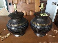 Pair of black textured table lamp bases with cords and brass sockets shown from side angle