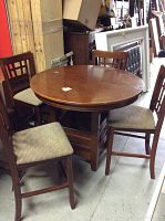 Round oak table with four matching oak chairs, visible tabletop and chair seats.