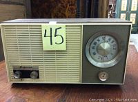 Front view of vintage Minerva radio showing speaker grill, tuning knobs, and large circular tuning dial with frequency numbers.