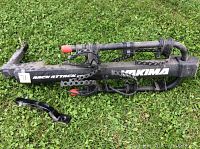 Side view of Yakima RackAttack 2.0 bike rack on grass, including separate hitch mount bracket piece.