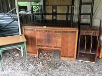Wide shot of all four items grouped together: metal child desk, wooden waterfall server, small file cabinet, glass TV stand.