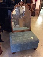 Photo showing the ottoman in front of the walnut mirror with carved arched top detail.