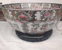 Bowl displayed on wooden stand, showing exterior pattern and stand design