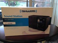 Front view of the SiriusXM Sound Station WiFi Table Radio box showing product branding and features.