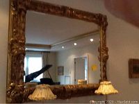 Mirror hung above sideboard showing full frame and reflection
