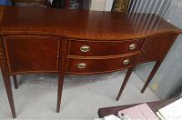 Front angle view of mahogany sideboard server buffet showing serpentine front, drawers, cabinets and tapered legs