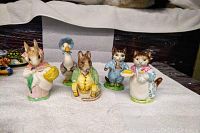 Front view of all five Beatrix Potter figurines: Mrs. Rabbit, Ribby, Samuel Whiskers, Jemima Puddle Duck and Tom Kitten, showing size and paint detail