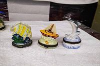 Three small ceramic fish-themed boxes displayed side by side on a light surface showing the variety of designs