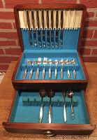 Full view of the Wm Rogers & Sons silverplate flatware set in blue felt lined wooden storage box with upper and lower compartment showing multiple types of flatware.