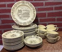 Set of stacked plates, cups and berry bowls displayed showing quantity and pattern.