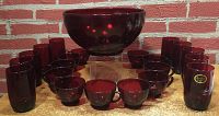 Full lot photo showing the large Royal Ruby punch bowl surrounded by 11 matching cups and 10 tumblers in deep red glass.