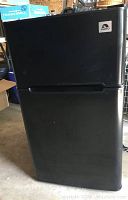Black Igloo dorm size refrigerator freezer with 2 doors closed, showing front exterior with brand logo.