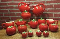 Group shot showing all tomato-shaped ceramic serveware pieces including pitchers, jars, creamers, sugar bowls, and salt & pepper shakers