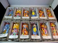 Open box showing 12 individually boxed animal candles arranged in two rows of six.