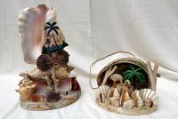 Front view of both shell art lamps showing painted palm tree scenes, various shells and coral arrangements on bases.