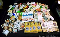 Wide view of large assorted vintage matchbooks and covers laid out on a flat surface.