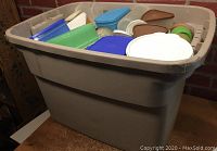 Large plastic bin filled with assorted vintage Tupperware containers in multiple colors and shapes, mostly with lids.