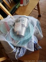 Mesh dunk bags with various picnic items, including Melmac dishware and cloths.