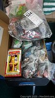 Box containing multiple McDonald's figures in sealed plastic packaging, including dolls and other characters.