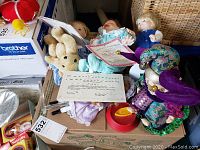 Overview of all dolls and stuffed bear, some with papers and boxes, showing condition and included items.
