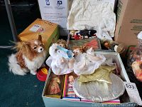 Photo showing assortment of international dolls, porcelain angels, and stuffed dog