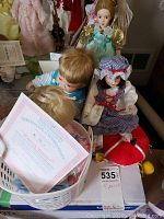 Group photo of four collectible porcelain dolls with certificates, including Little Jamie, Little Miss Muffet, Christopher's First Smile and Fairy Godmother dolls.