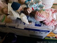 Four dolls laid on a box including two Little Boy Blue dolls by Knowles and two Ashton Drake dolls, showing overall lot