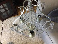 Top view showing silver chandelier frame with three candle-shaped light holders and hanging clear crystal bead chains.