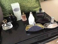 Overview of nine fragrance bottles on black surface